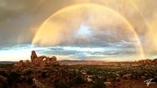 A double rainbow sunrise over Turret Arch in Arches National Park